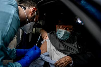 ITALIA: Un trabajador sanitario administra una dosis de la vacuna COVID-19 a un anciano, en las instalaciones del Hospital Militar Baggio de Milán, Italia, el 4 de marzo.