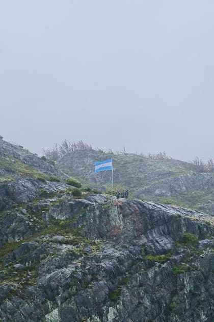 Izamiento de la bandera Argentina en Punta Bandera, a donde iban originalmente los diez fallecidos en el 2001