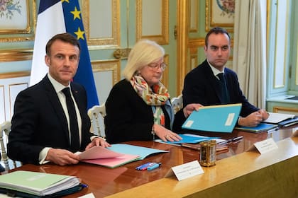Izquierda a derecha, el presidente francés Emmanuel Macron, la ministra de Trabajo, Catherine Vautrin y el ministro de Defensa, Sebastien Lecornu, asisten a la primera reunión del nuevo gabinete, 12 de enero de 2024 en el Palacio del Eliseo, en París. (AP Foto/Michel Euler, Pool)