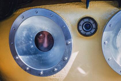 Jacques Cousteau mira por el ojo de buey de un platillo de buceo SP-350 Denise en 1960, en una imagen difundida por National Geographic del documental "Becoming Cousteau"