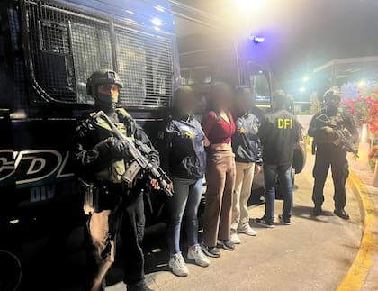 Jade Isabela Calláu Barriga, escoltada por agentes del Departamento Federal de Investigaciones de la Policía Federal Argentina, durante el operativo de deportación en el Aeropuerto Internacional de Ezeiza