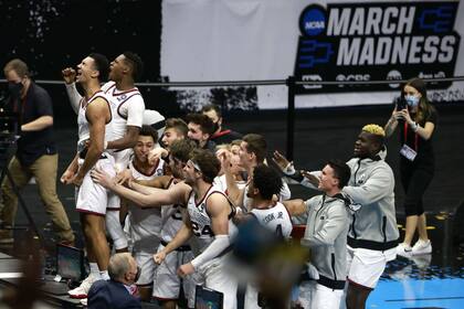 Jalen Suggs festeja con todos sus compañeros el agónico triple que convirtió desde mitad de cancha para meter a Gonzga en la final del Final Four