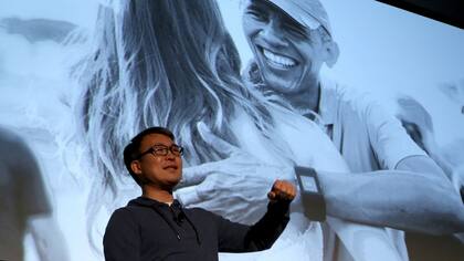 James Park, CEO de FitBit, con la imagen de Obama de fondo, el usuario más célebre de la pulsera inteligente