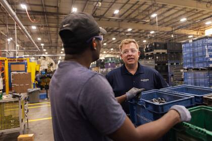 Jamie McGregor, director ejecutivo de McGregor Metal, habla con Daniel Campere, un inmigrante haitiano que trabaja en la empresa, en Springfield, Ohio, el 26 de agosto de 2024.
