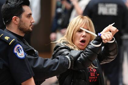 Rosanna Arquette agita los puños mientras es detenida por los oficiales
