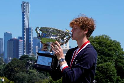 Jannik Sinner besando el trofeo de campeón del Australian Open, en el Jardín Botánico de Melbourne