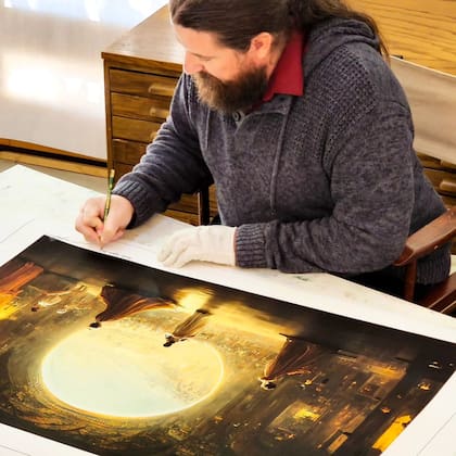 Jason Allen firmando una copia impresa de la imagen que creó con Midjourney y con la que ganó un concurso de arte