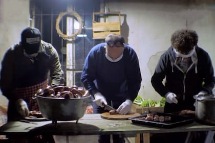 Molina junto a dos de sus amigos, quienes lo ayudan todos los días a preparar más de 300 porciones de comida