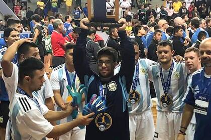 Javier Fernández arquero de la Selección Argentina de Futsal Síndrome de Down levanta el trofeo de sub campeón, conseguido anoche en Brasil