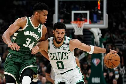 Jayson Tatum, de los Celtics de Boston, trata de eludir a Giannis Antetokounmpo, de los Bucks de Milwaukee, dos potencias de la conferencia este se miden en este especial navideño de la NBA