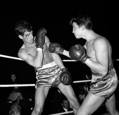 Jean-Paul Belmondo (izq.) esquiva un golpe durante un match de box en París, en 1960; el intérprete tuvo una fructífera carrera como estrella de acción