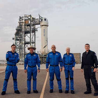 Jeff Bezos en el primer vuelo tripulado de Blue Origin. A su lado, Oliver Daemen, un estudiante holandés que con solo 18 años se convirtió en julio de 2021 en la persona más joven en la historia en viajar al espacio. Detrás, la nave New Shepard