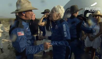Jeff Bezos junto a la también pasajera Wally Funk, junto a la nave tras aterrizar.  La cápsula New Shepard de Blue Origin culminó con éxito su primer vuelo tripulado al límite del espacio este 20 de julio, con el fundador de la compañía, Jeff Bezos, y otros tres pasajeros a bordo.  