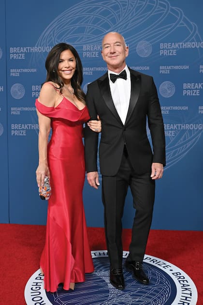 Jeff Bezos y Lauren
Sánchez sonríen en la red carpet. La periodista
optó por un vestido
asimétrico vintage de
John Galliano que ya
había lucido Raquel
Welch.