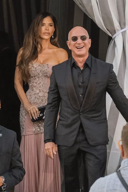 Jeff y Lauren salen del hotel
Aman rumbo a la “Dolce Notte”,
la gran fiesta organizada en el
Arsenale, los viejos astilleros del
siglo XIV. La periodista impactó
con un romántico strapless con
aplicaciones de brillos.