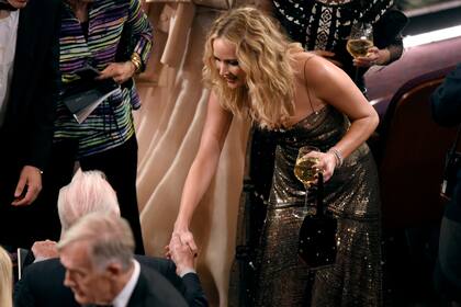 Jennifer Lawrence, como cualquier mortal, disfrutando de bebidas y de un saludo de Christopher Plummer