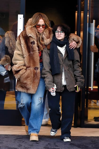 Jennifer Lopez –con saco de piel con capucha y jeans anchos– junto a su hija Emme.