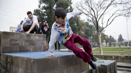 Jeremías Barraza hace su práctica de parkour en compañía de su instructor, Tiago Caragliano, en la plaza Arturo Illia