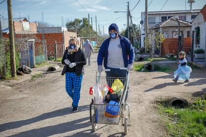 Jesi y Enzo recorren el barrio buscando los recipientes