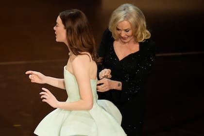Jessica Lange, derecha, ajusta el vestido de Emma Stone durante los Oscar el domingo 10 de marzo de 2024 en el Dolby Theatre de Los Ángeles