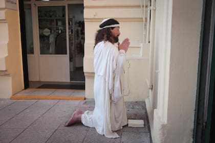 Jesús, un fiel que camina descalzo desde el barrio de Del Viso hasta Luján, reza de rodillas frente al santuario de San Cayetano antes de iniciar su travesía