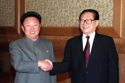 En esta foto de archivo tomada el 1 de junio de 2000, el presidente chino Jiang Zemin (derecha) le da la mano al líder norcoreano Kim Jong-il en Pekín
