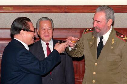 El entonces presidente cubano Fidel Castro, a la derecha, y el entonces presidente chino Jiang Zemin brindan después de presidir una ceremonia de firma en el Gran Salón del Pueblo de Pekín