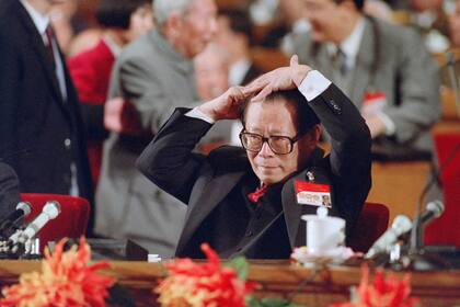 En esta foto de archivo tomada el 12 de octubre de 1992, el secretario general del Partido Comunista Chino, Jiang Zemin, se peina justo antes de su discurso ante el XIV Congreso del PCCh en Pekín