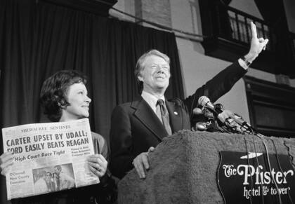 Jimmy Carter hace la señal de la victoria mientras su esposa, Rosalynn Carter, sostiene un periódico después de ganar la primaria presidencial demócrata de Wisconsin el 7 de abril de 1976.