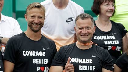 Jiri Vanek (izquierda) y otros integrantes del equipo de petra Kvitova, sonrientes en el palco. "Valor" y "creer", los mensajes de apoyo a la jugadora estampados en sus remeras