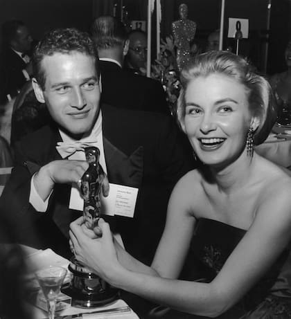 Joanne Woodward sostiene su estatuilla del Oscar mientras está sentada junto a su esposo, el actor estadounidense Paul Newman, durante el Governor's Ball, una fiesta de los Premios de la Academia celebrada en el Hotel Beverly Hilton, de Beverly Hills, California. En 1958 la actriz se consagró por su trabajo en Las tres caras de Eva