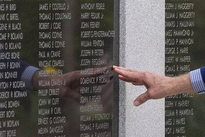 Joe Biden, al tocar el nombre de su tío Ambrose J. Finnegan que está grabado en el monumento, en Scranton. (AP/Alex Brandon)