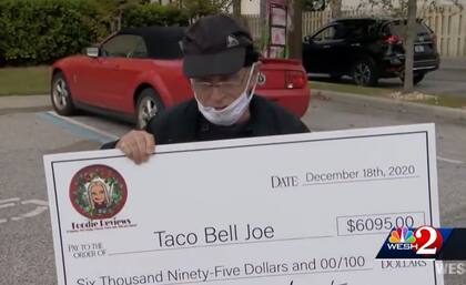 Joe DeCicco, más conocido como Taco Bell Joe, exhibe con orgullo el cheque que le obsequió su comunidad