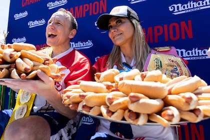 Joey Chestnut y Miki Sudo posan con 63 y 40 "hot dogs", respectivamente, tras ganar el concurso de perros calientes que organiza Nathan's Famous por el 4 de Julio en Coney Island, el lunes 4 de julio de 2022, en Nueva York. (AP Foto/Julia Nikhinson)