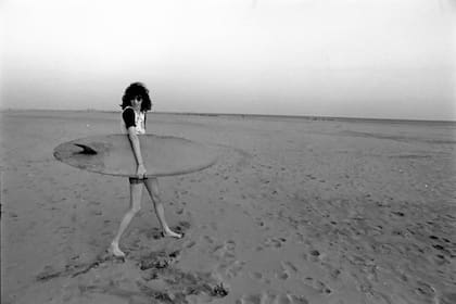 Joey Ramone sostiene una tabla de surf en Coney Island, a fines de la década de los 70