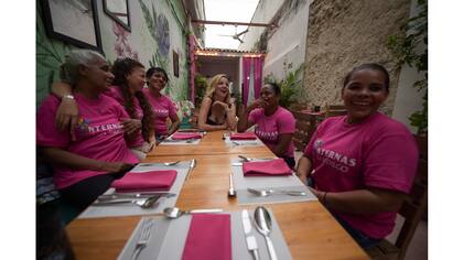 Johanna Bahamon, al centro, directora de la fundación Internal Theatre, que financia el proyecto, habla con las presas que trabajan en el restaurante