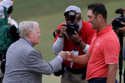 Jon Rahm, de España, es felicitado por el legendario Jack Nicklaus después de ganar el torneo Memorial