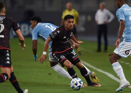 Jonás Acevedo, volante de Huracán, maniobra ante la marca de Jesús Castillo, mediocampista de Sporting Cristal