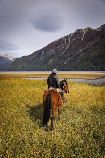 Jonathan Coronado guía cabalgatas que cruzan el río Carrileufu en la desembocadura del lago Rivadavia