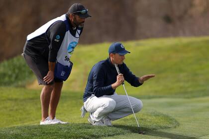 Jordan Spieth conversa con su caddie Michael Greller; el asistente le pidió insistentemente al número 15 del mundo que no se arriesgue, pero no le hizo caso