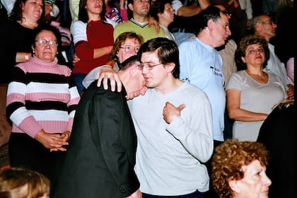 Jorge Bergoglio reza junto a un joven en el encuentro ecuménico en el Luna Park