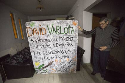 Jorge con el afiche que hicieron los amigos de David para despedirlo.