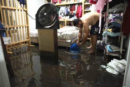 Jorge Gabriel Villalba saca agua de su habitación inundada