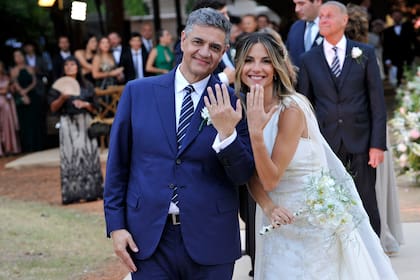 Jorge Macri y María Belén Ludueña muestran sus alianzas a los fotógrafos. La pareja logró realizar la ceremonia civil y la fiesta el mismo día. Es el segundo matrimonio de Macri y el primero de la conductora.