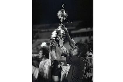 Jorge Ribolzi de Boca Juniors, al frente, sostiene el trofeo después de la tanda de penales de la final de la Copa Libertadores de fútbol contra el Cruzeiro de Brasil en Montevideo, Uruguay, el miércoles 14 de septiembre de 1977.