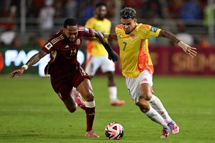 José Martínez y Luis Diaz en la lucha por el balón (Photo by Juan BARRETO / AFP)