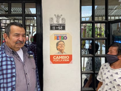 José Ruperto Cincuentis y Marco Eli Vega junto a un cartel de la campaña de Gustavo Petro