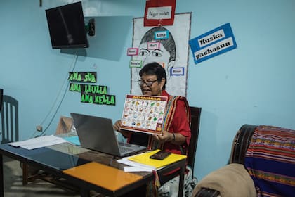 Josefina Álvarez, profesora de quechua, muestra un alfabeto virtualmente desde Lima, a un grupo de estudiantes de la escuela del barrio donde vive. Josefina enseña quechua desde hace más de 30 años