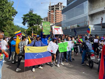 Jóvenes alzan carteles con llamados al fin del gobierno de Nicolás Maduro