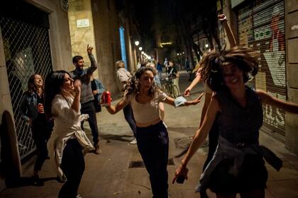 Jóvenes bailan en la calle pasadas las 12 de la noche del 9 de mayo de 2021 en -Barcelona, España